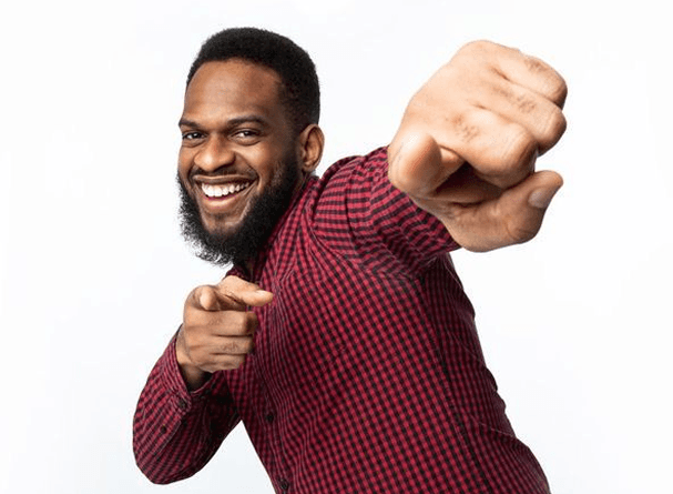 A smiling man pointing toward the viewer
